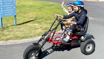 Una persona che guida un triciclo con un bambino.