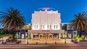 A theater with a marquee reading "EMPIRE" and a modern facade with large windows.