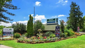 A motel sign with a garden in front.