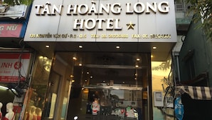 Exterior del Hotel Tân Hoàng Long con su nombre e información de contacto.