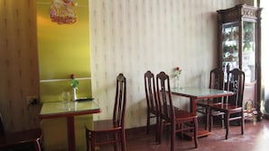 Un comedor con una mesa y sillas, un adorno en la pared y un aparador con puertas de cristal.