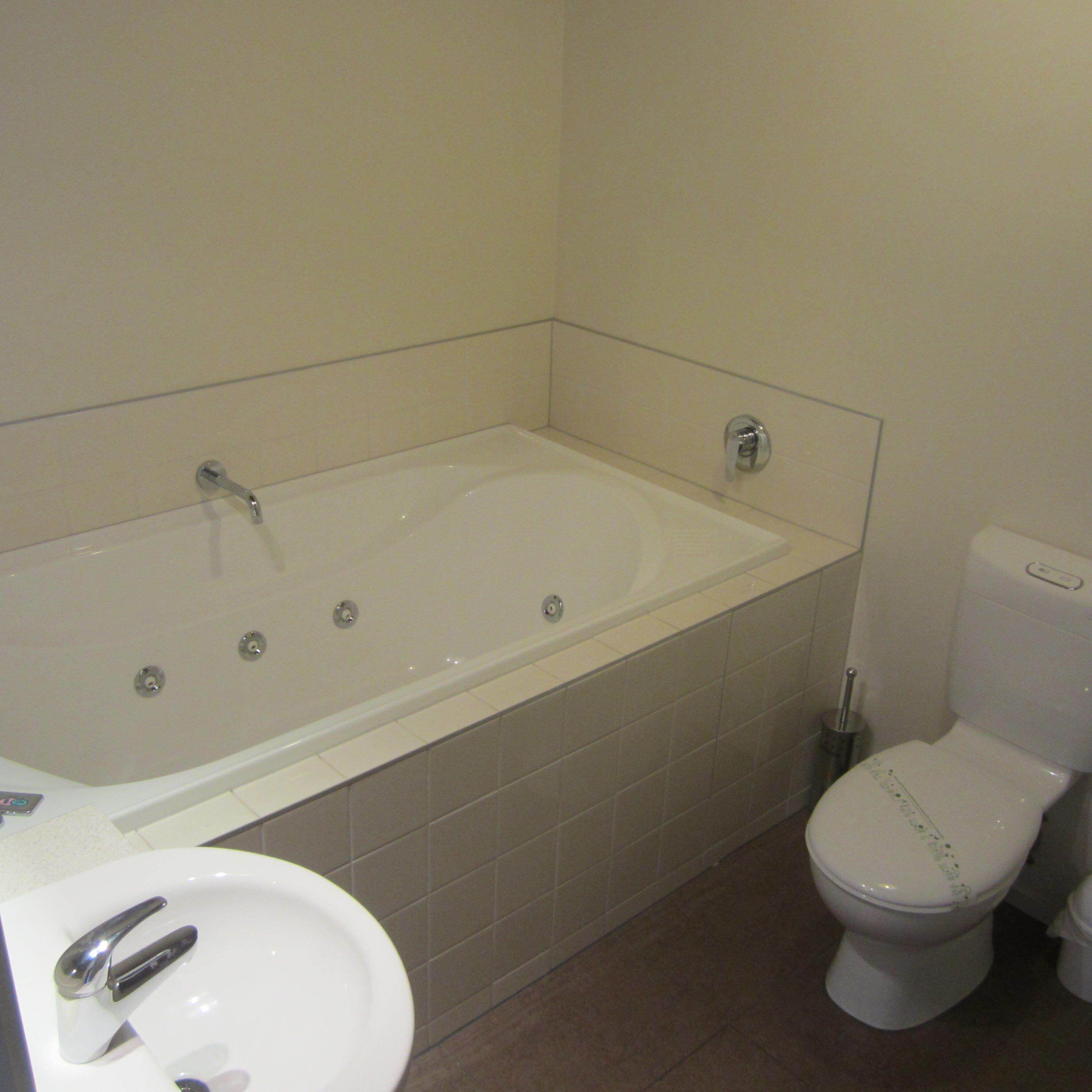 A bathroom with a bathtub, toilet, and sink.