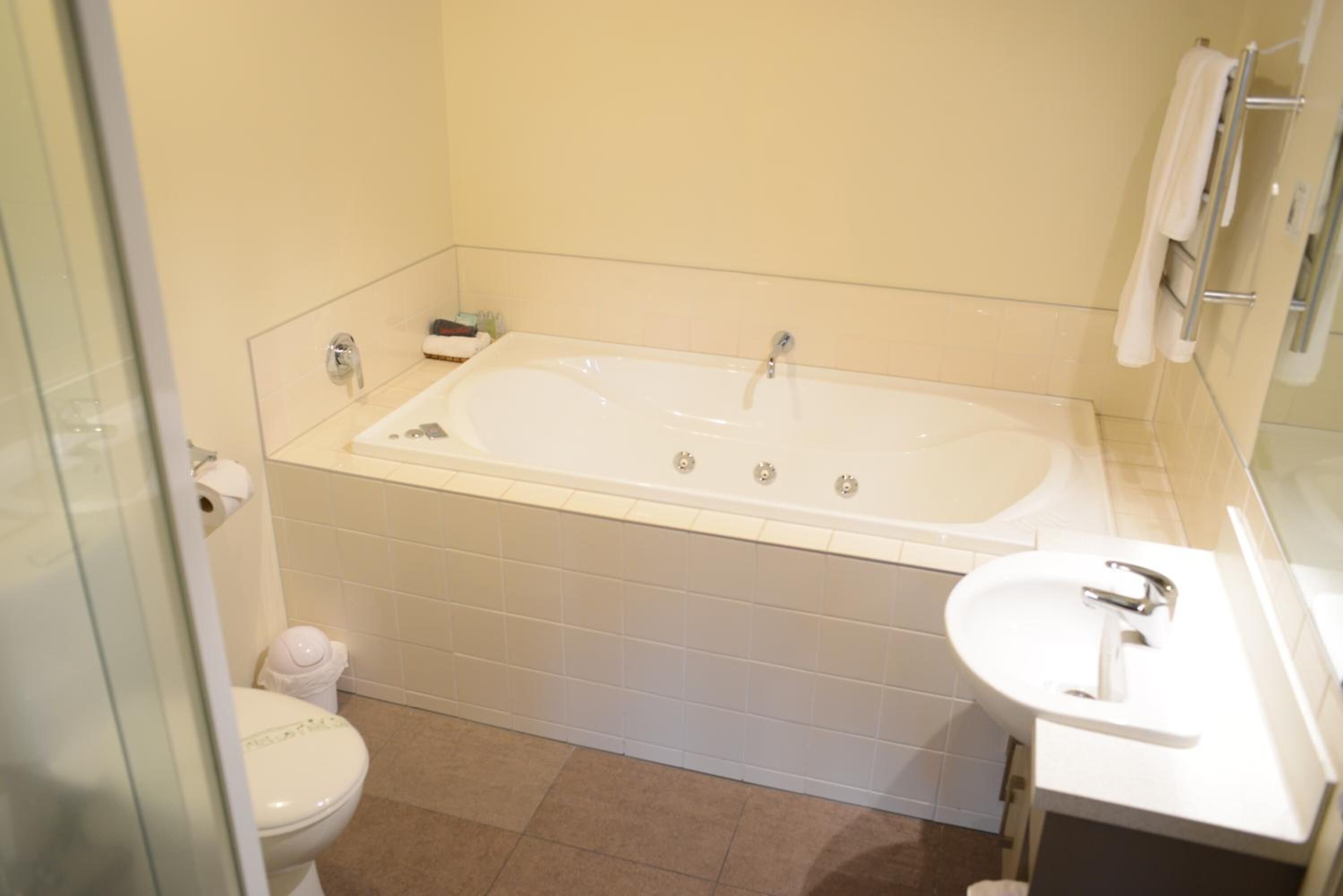A bathroom with a bathtub, toilet, and sink.