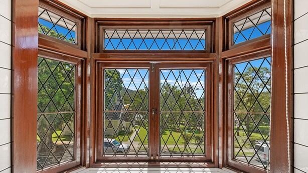 A bay window with a view of a green landscape and parked cars. - Canungra Hotel (Canungra)