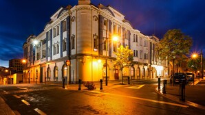 A historic building with arched windows and a classic facade, likely a hotel, with a well-lit street in front. - The Grosvenor (Timaru)