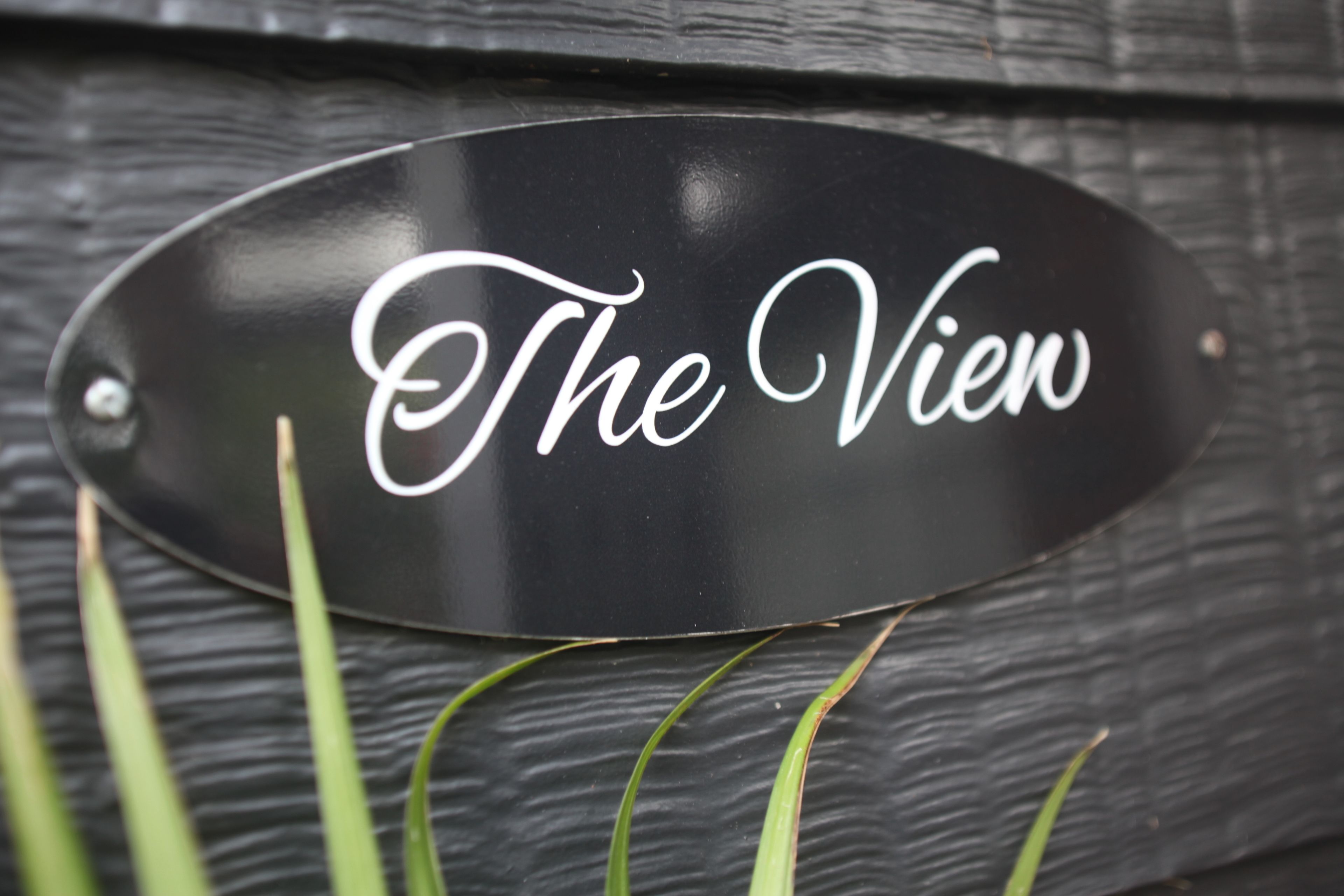A black sign with the text "The View" in white cursive font.