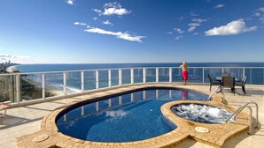 A rooftop pool with a hot tub, overlooking a city skyline and the ocean. - 2nd Avenue Beachside Apartments (Burleigh Heads)