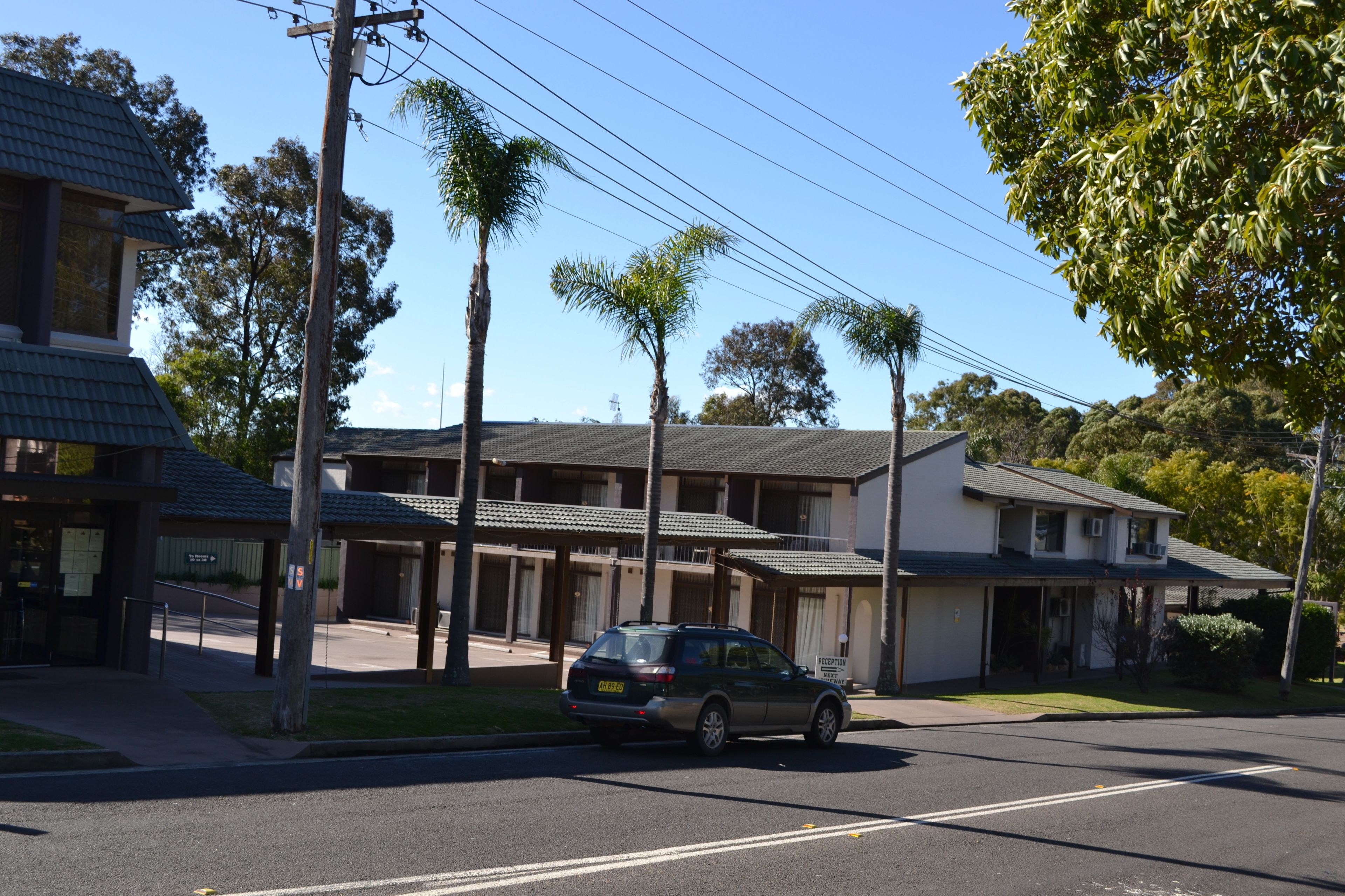 A two-story motel with a car parked in front.