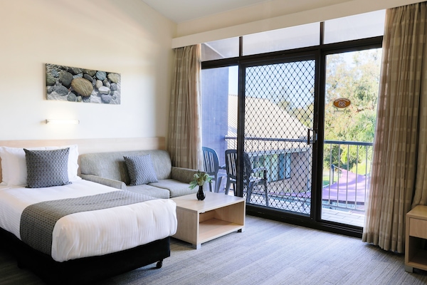 Escritorio, cortinas blackout y tabla de planchar con plancha