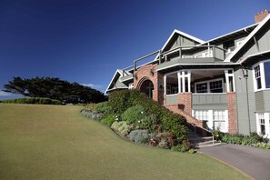 A modern house with a brick facade, a covered porch, and a well-maintained lawn. - Barwon Heads Golf Club (Barwon Heads)