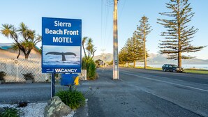 A motel sign with a whale tail and a vacancy notice. - Sierra Beachfront Motel (Kaikoura)