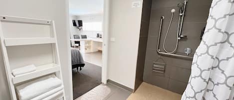 Une salle de bain moderne avec une douche, un porte-serviettes et un petit tapis.