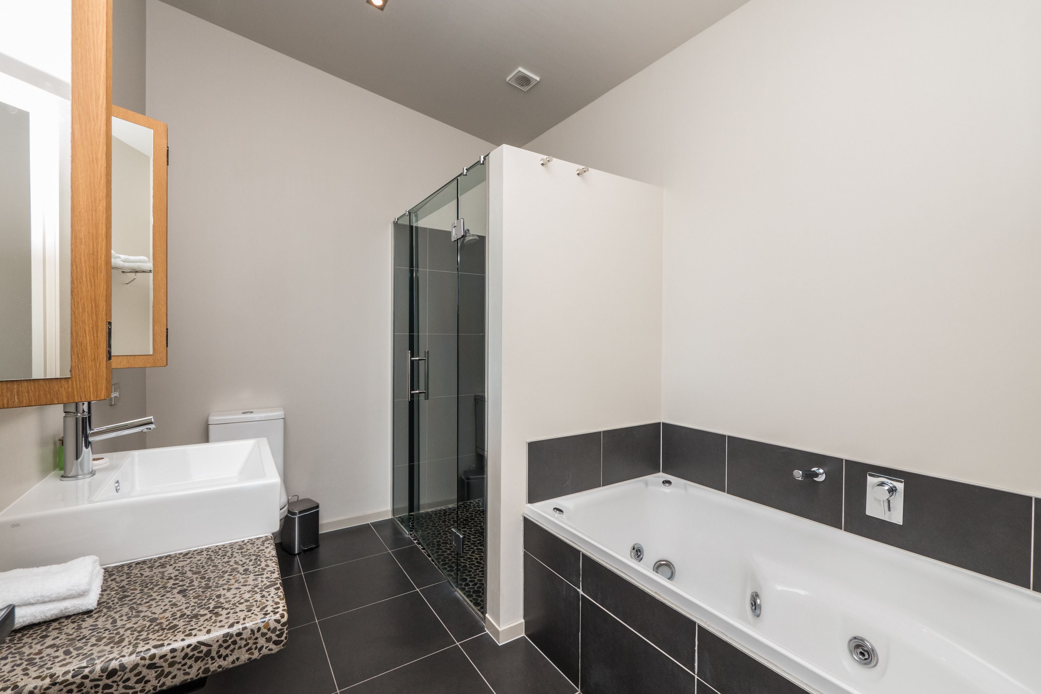 A modern bathroom with a white sink, a freestanding bathtub, and a glass-enclosed shower.