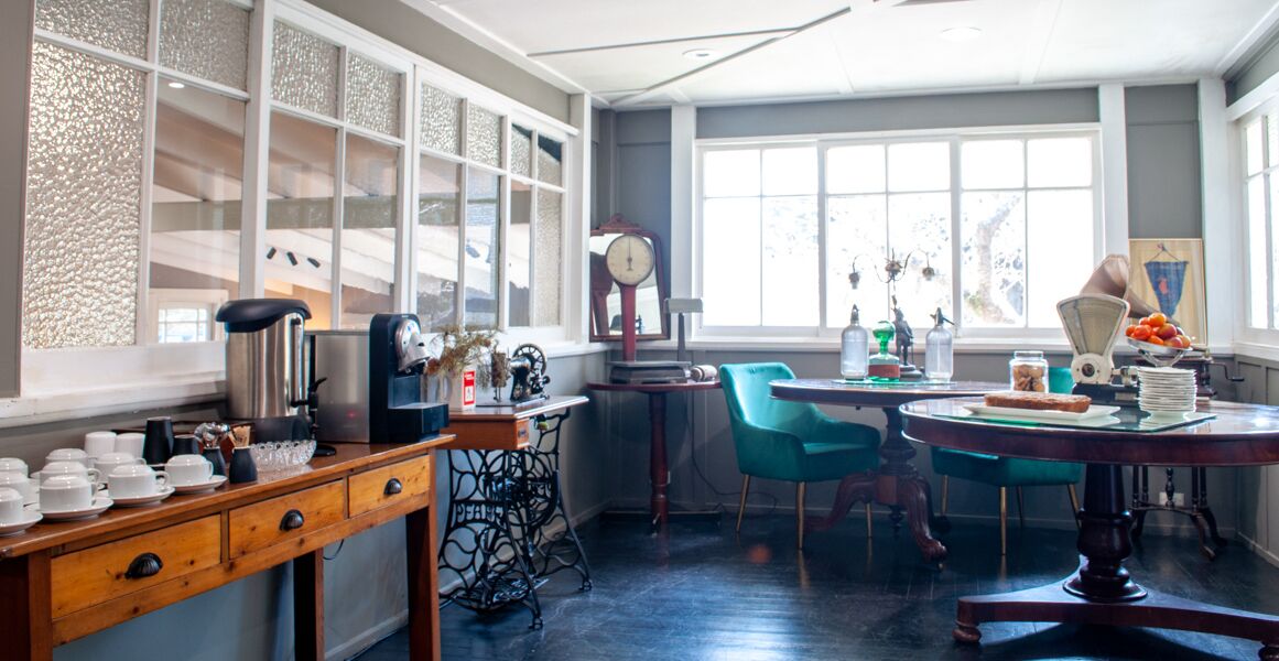 Una cocina con una mesa de madera, una silla azul y un ventanal con vistas.