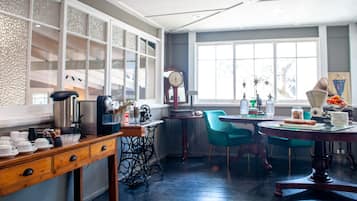 Una cocina con una mesa de madera, una silla azul y un ventanal con vistas.