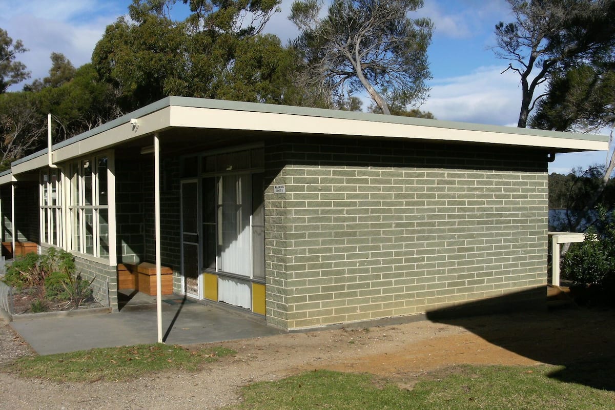 A modern building with a flat roof, large windows, and a brick exterior.