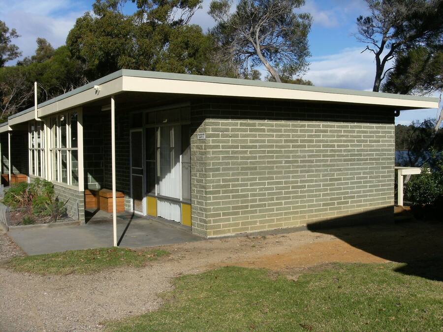 A modern building with a flat roof, large windows, and a brick exterior.