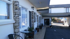 Un bâtiment doté de piliers en pierre, d’une terrasse et d’une allée couverte.