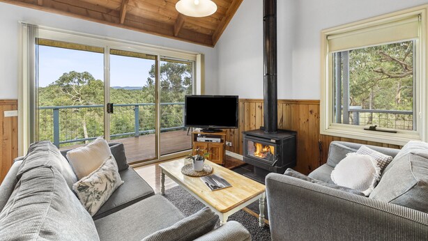 Una sala de estar acogedora con una televisión grande, una chimenea y asientos cómodos.