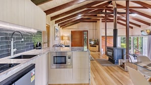 A modern kitchen with a built-in microwave, stainless steel sink, and wooden flooring. - Treetops Seaview Montville (Montville)
