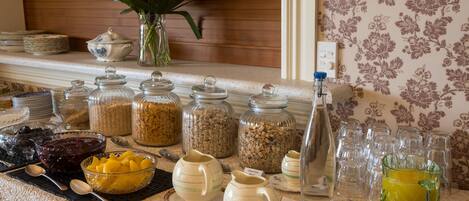 A buffet table with various food items and serving utensils.