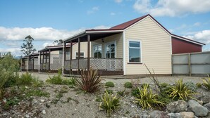 A two-story house with a covered porch and a fenced yard.
