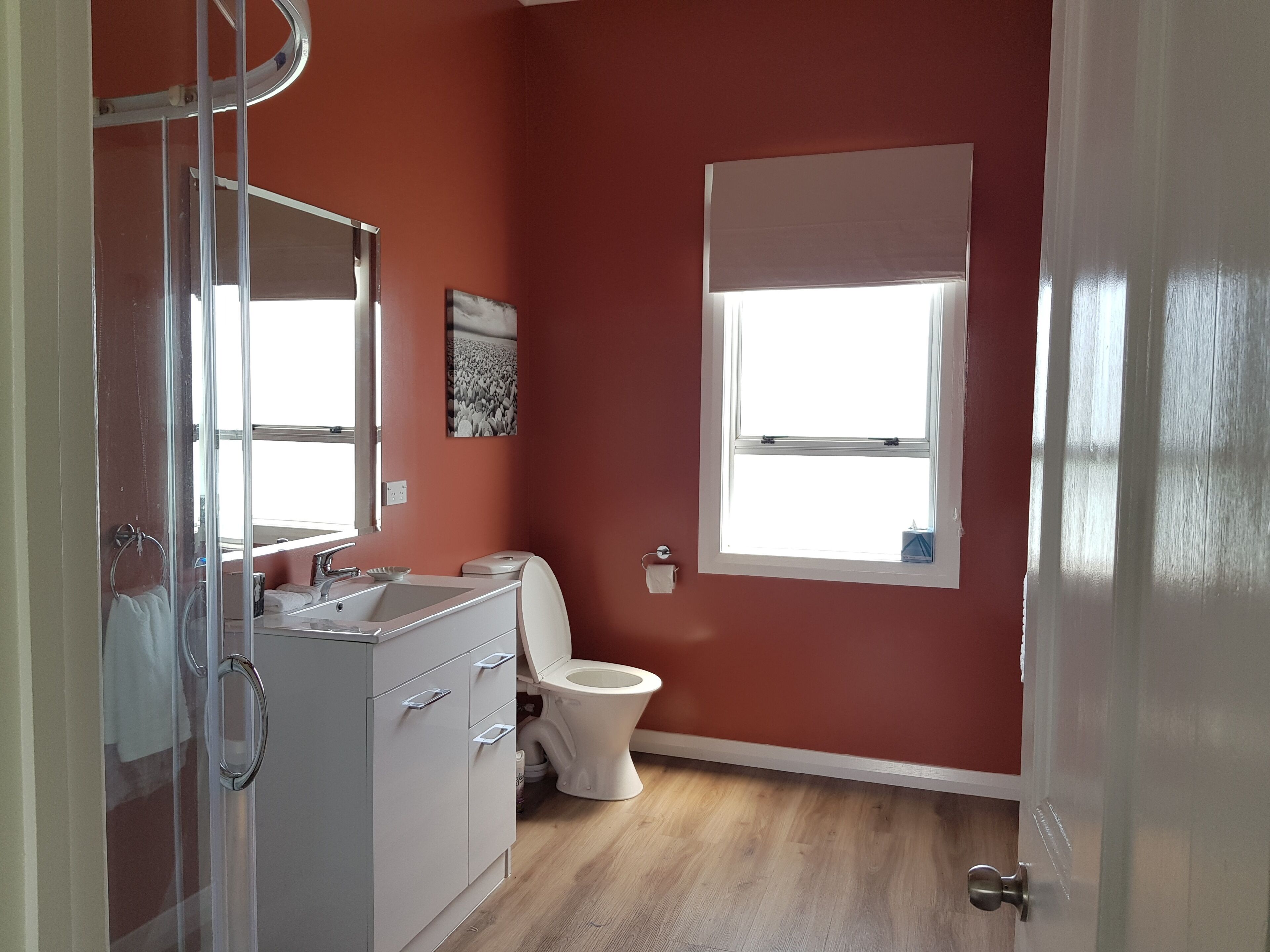 A bathroom with a toilet, sink, and mirror.
