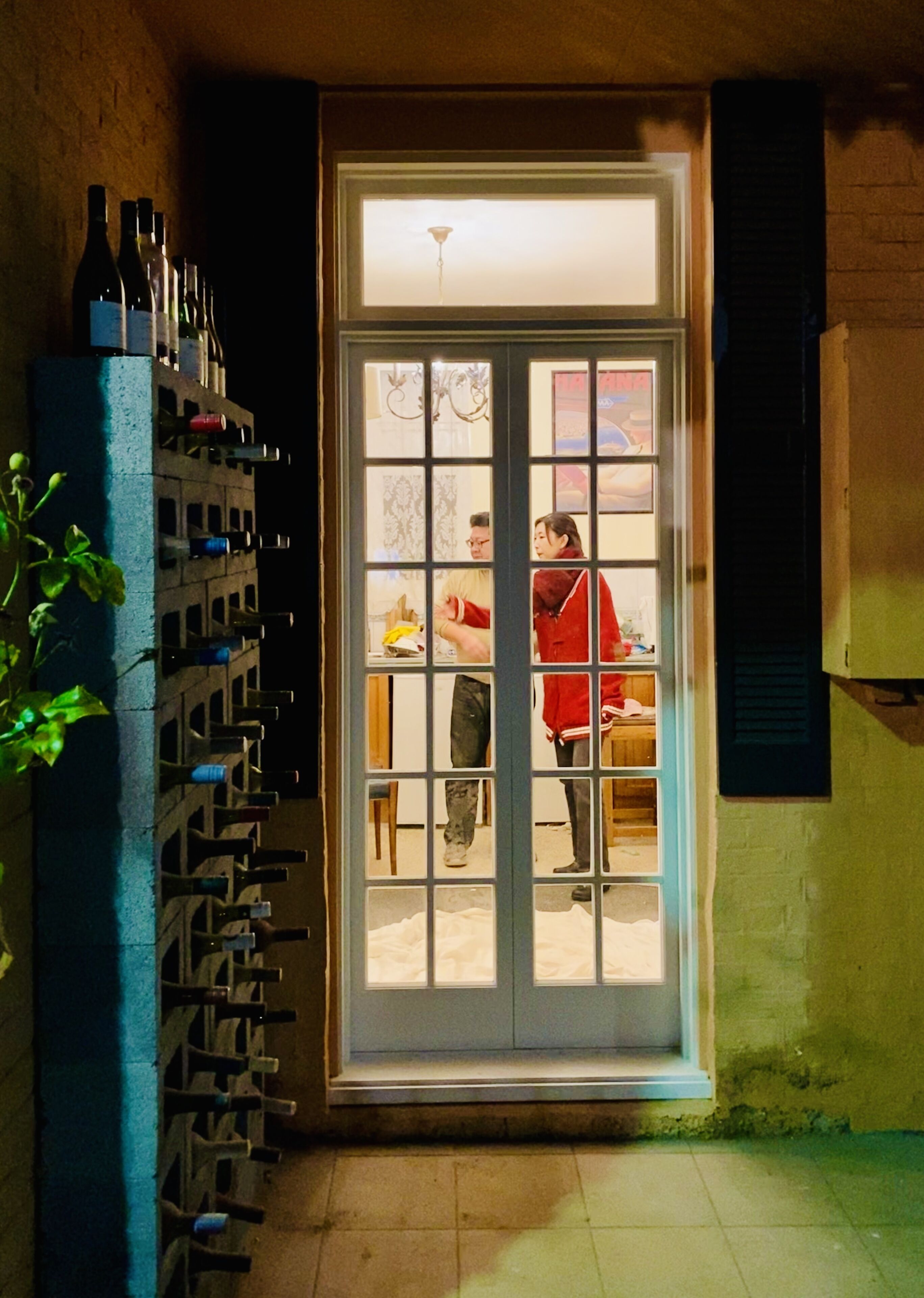 Una puerta con una estantería para vinos a la izquierda y una persona dentro.
