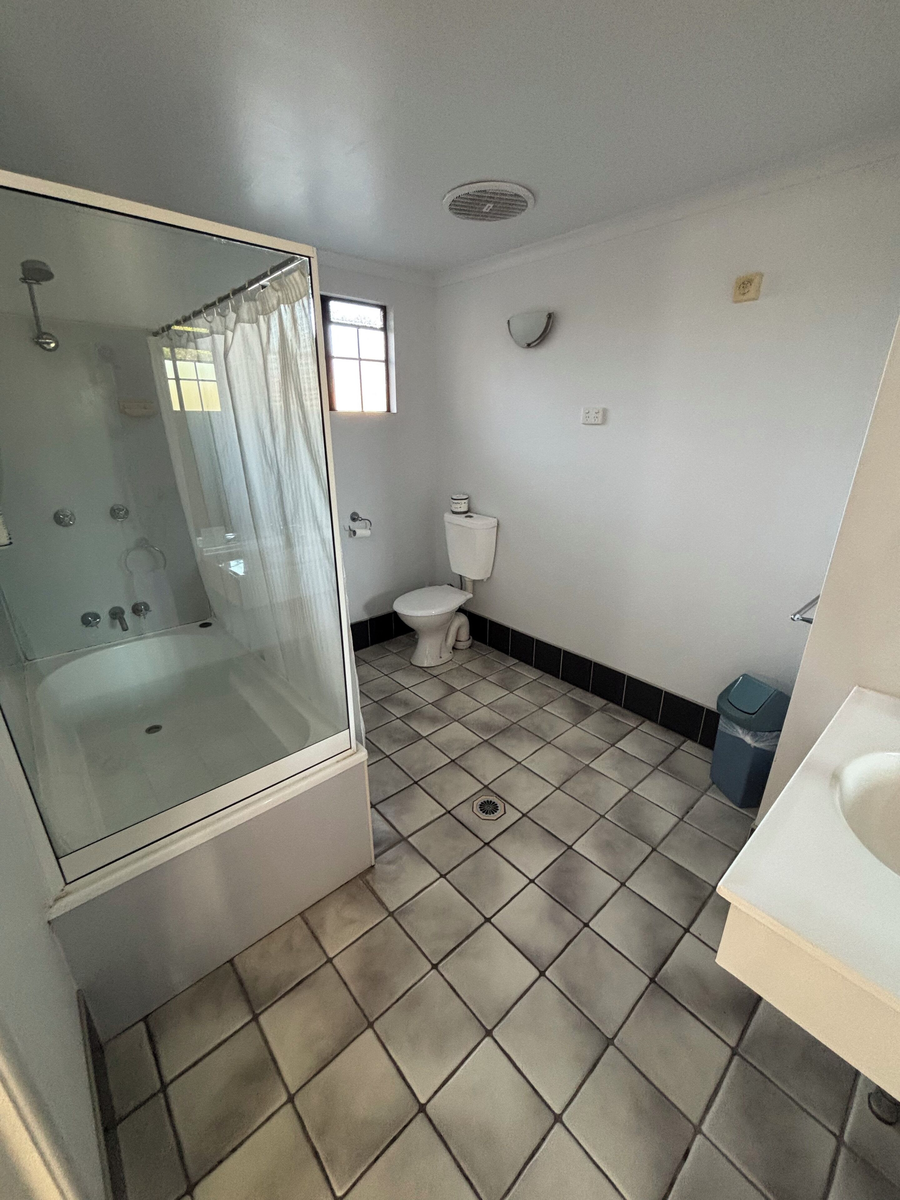 Un bagno con doccia vetrata, un water e un lavandino.