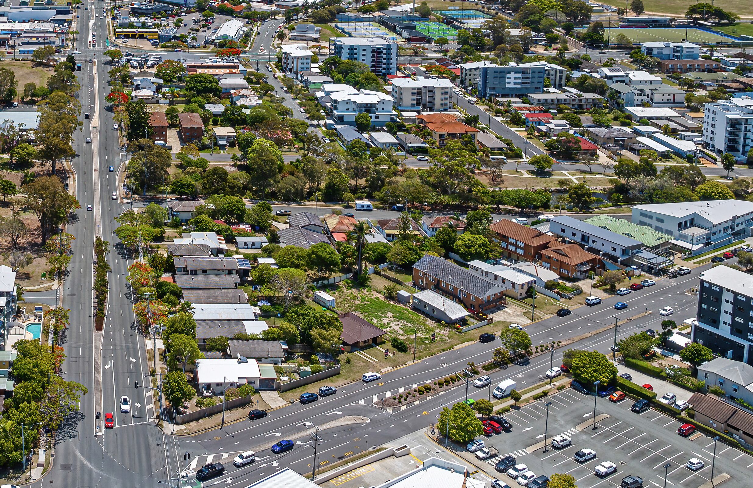 Vue aérienne d’un quartier résidentiel comprenant de nombreux immeubles, des routes et des véhicules.