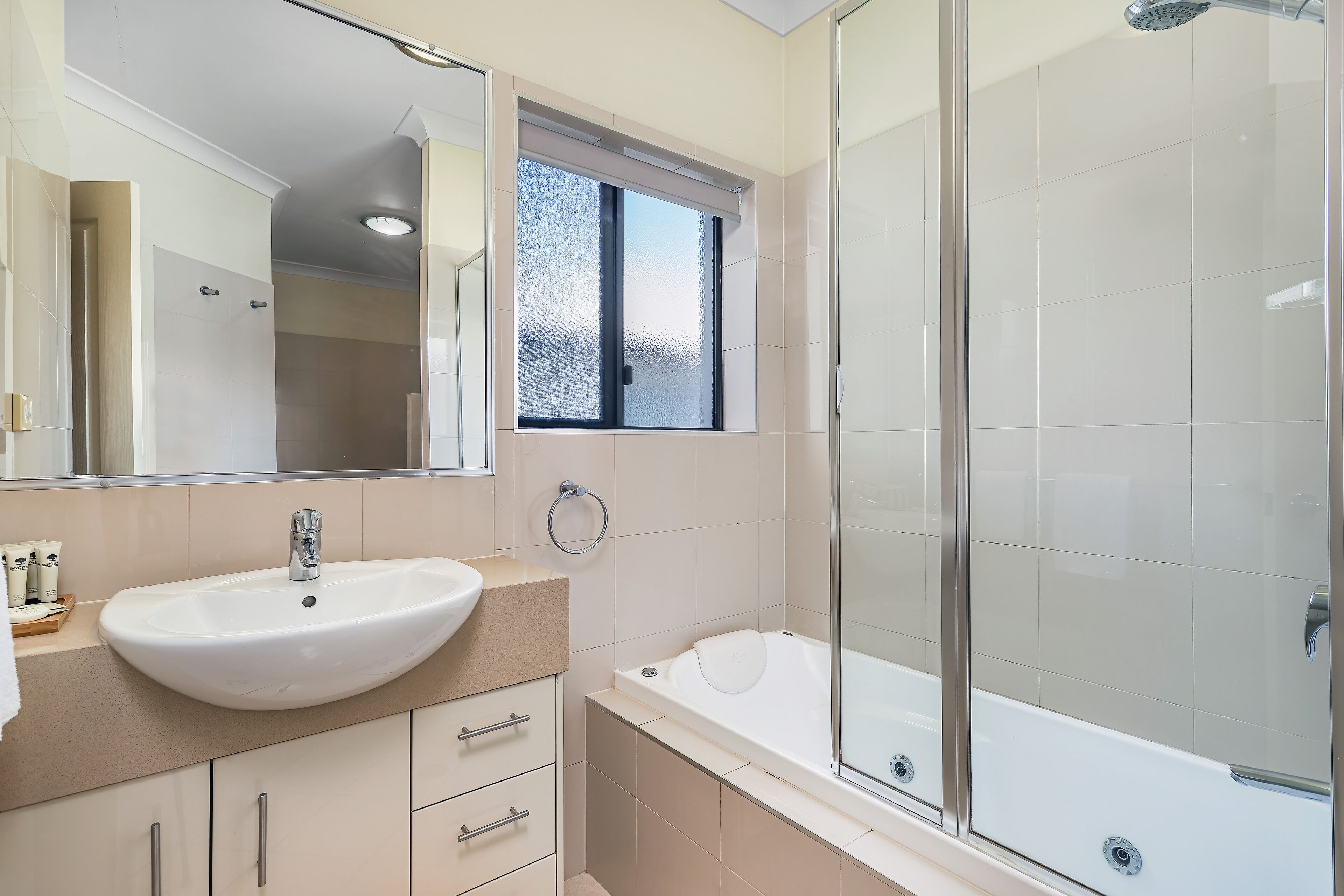 A modern bathroom with a large sink, a bathtub, and a glass-enclosed shower.