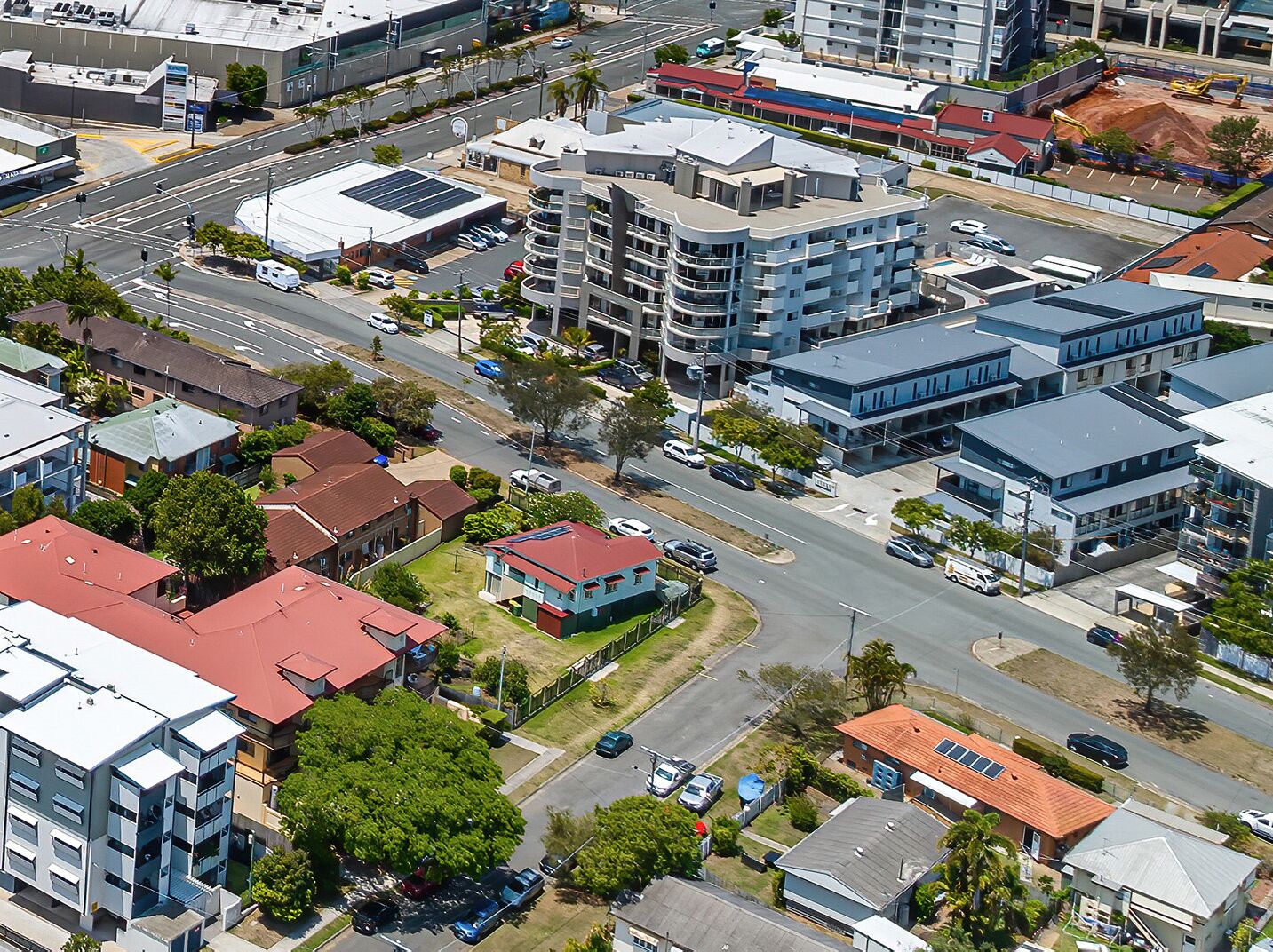 An aerial view of a cityscape with modern buildings, roads, and a construction site.