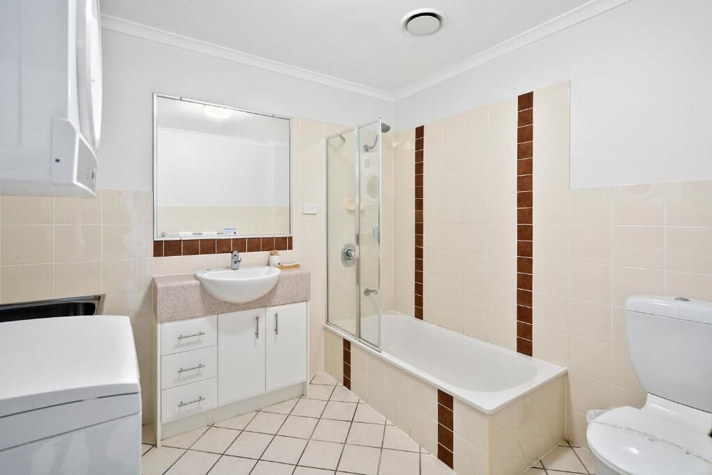 A bathroom with a shower, a sink, and a toilet.