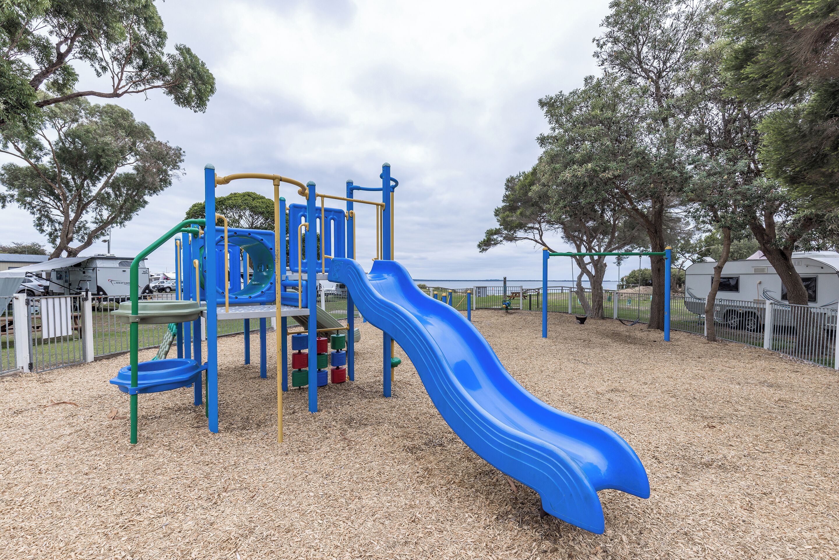 A playground with a blue slide and climbing structures.