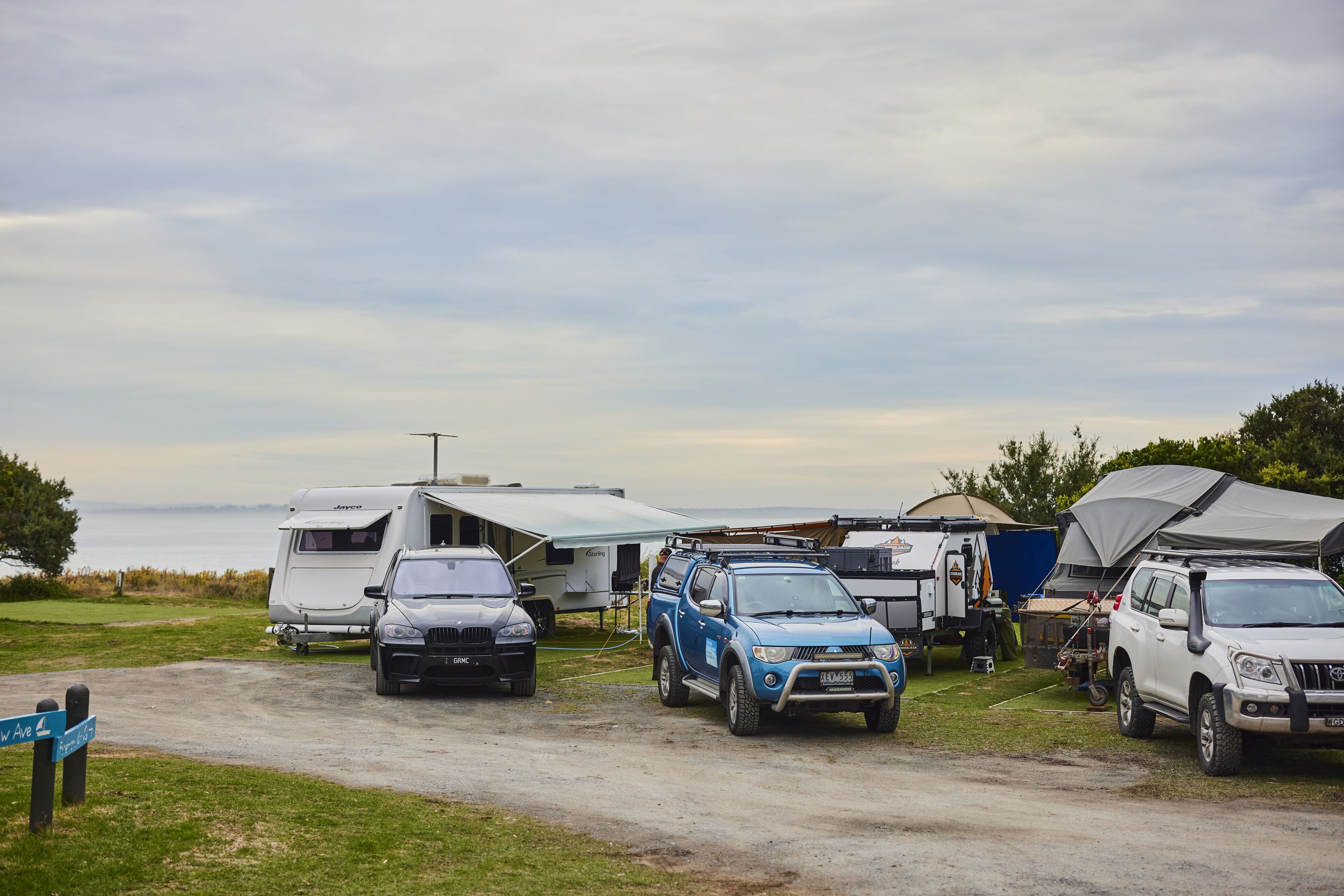 A campsite with RVs, SUVs, and a tented area.