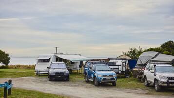 A campsite with RVs, SUVs, and a tented area.