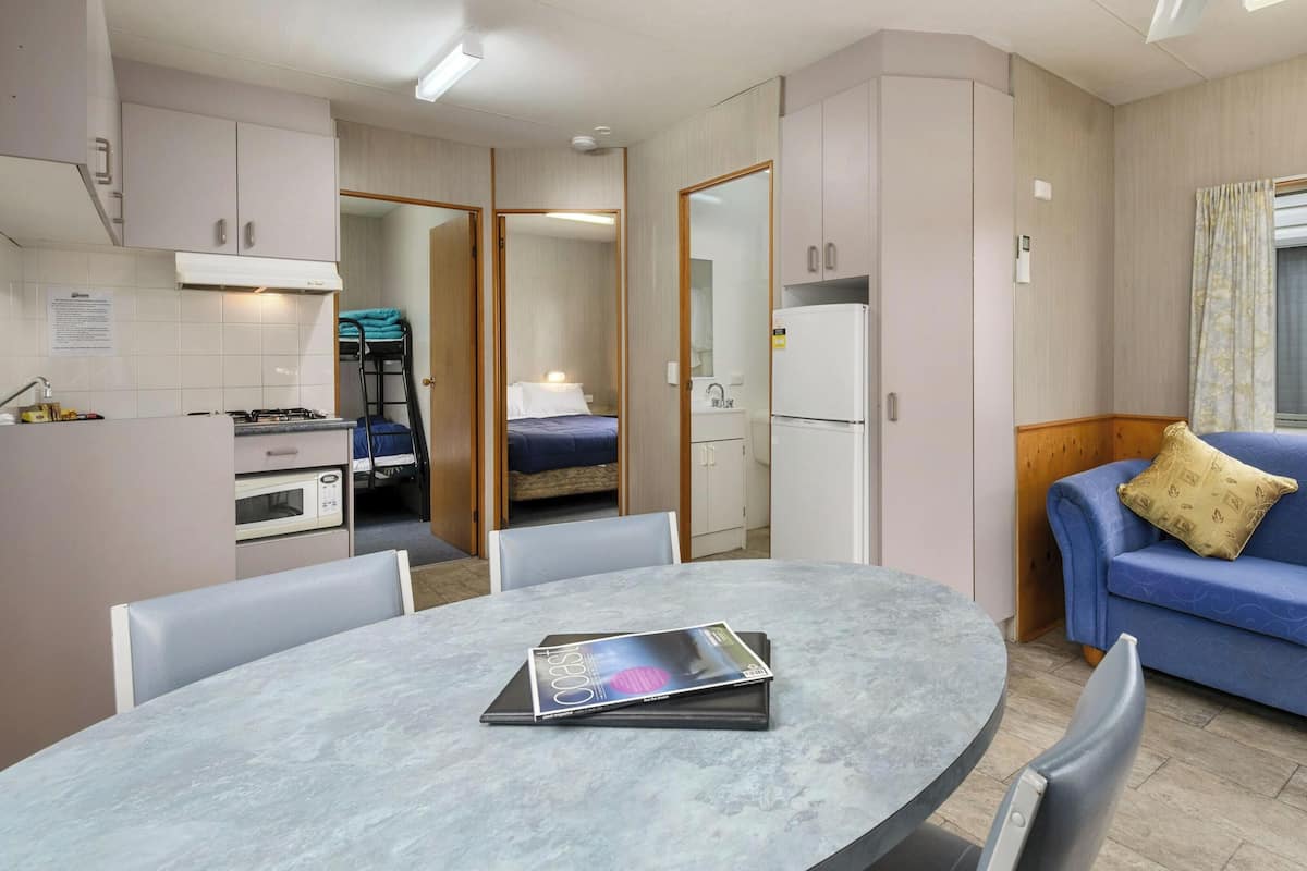 Une pièce compacte comprenant un coin cuisine, un lit, une table à manger et un canapé.