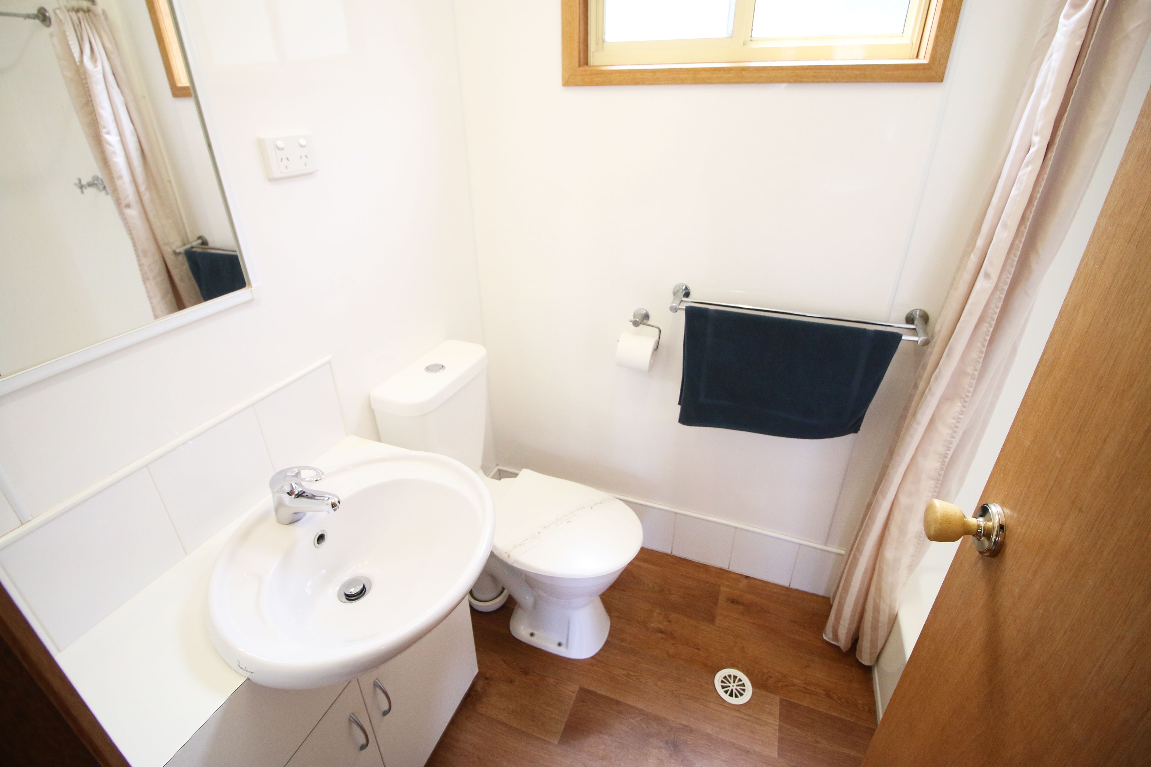 A small bathroom with a sink, toilet, and a towel rack.