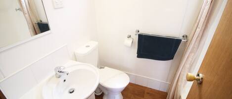A small bathroom with a sink, toilet, and a towel rack.