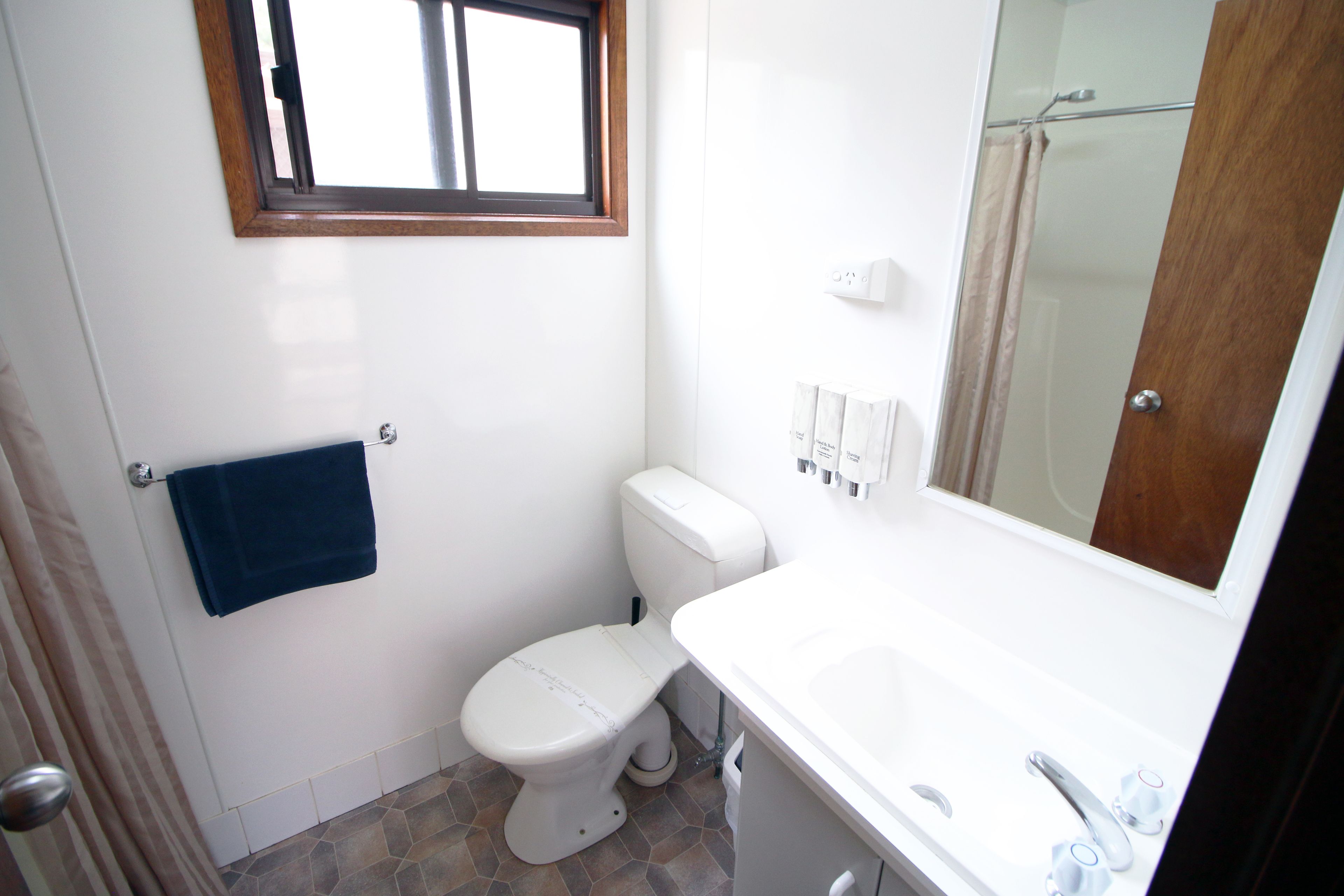 Een badkamer met toilet, wastafel en douche.