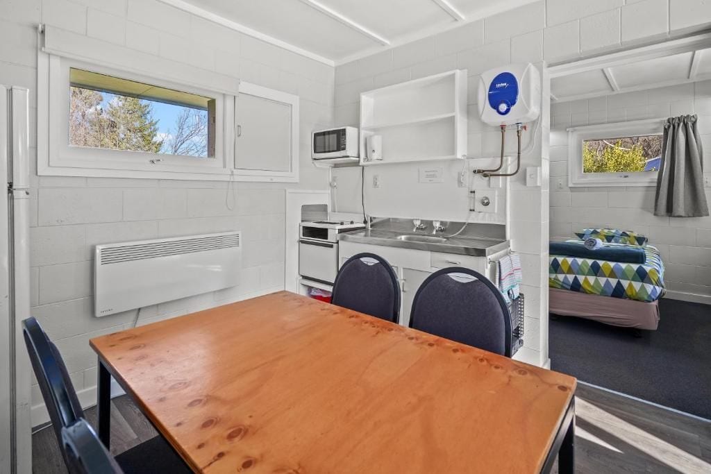 Cocina compacta con microondas, pileta y caldera. Cuentan con un pequeño comedor con mesa y sillas.