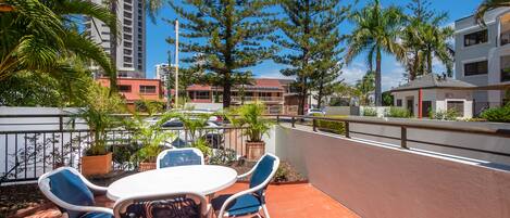 A patio with outdoor seating and a view of surrounding buildings.