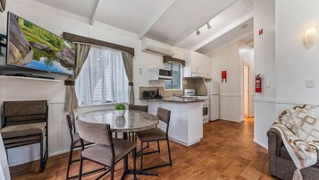 Un espacio habitable compacto con comedor, kitchenette y una zona de estar acogedora.