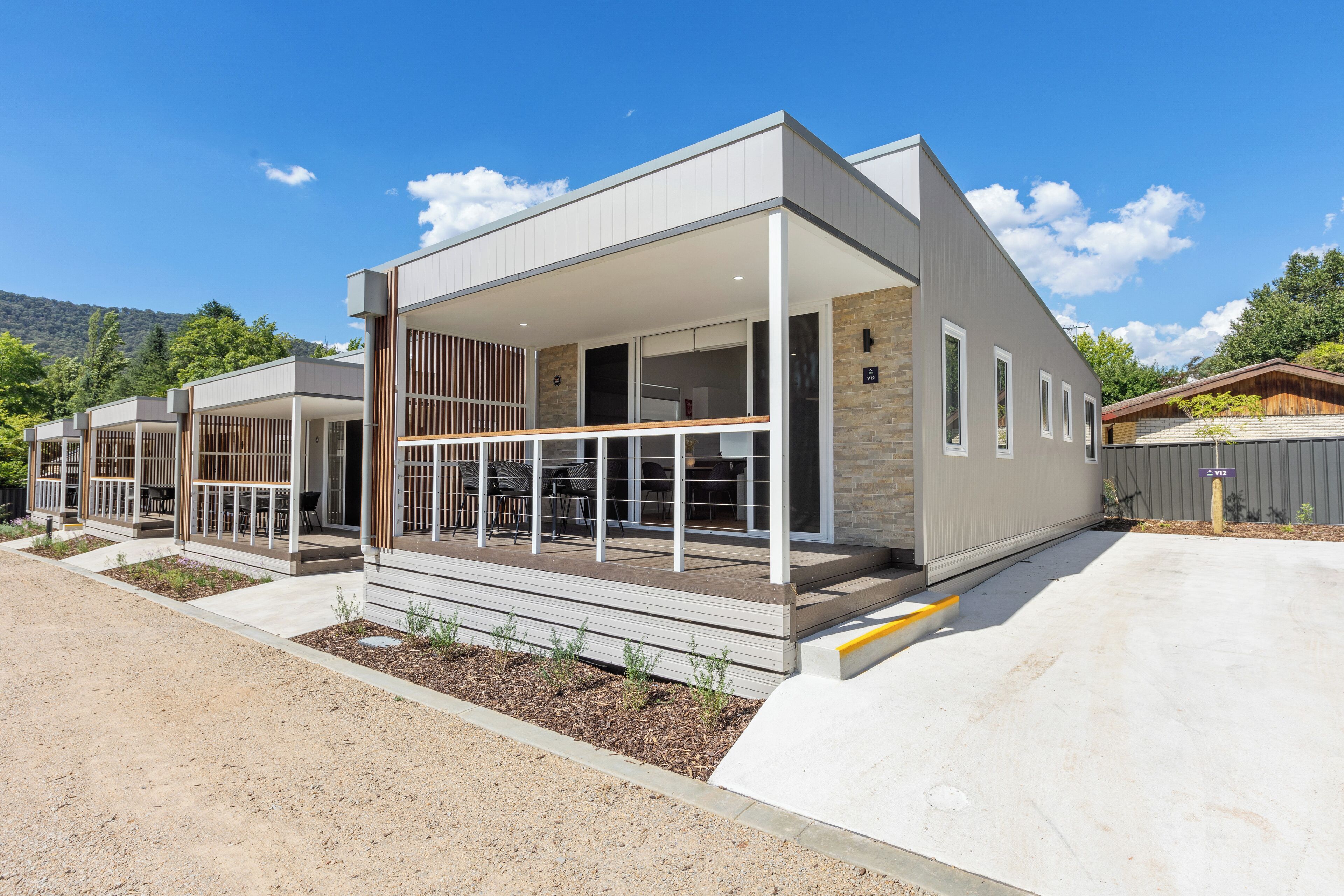 A modern two-story house with a covered patio area and a driveway.