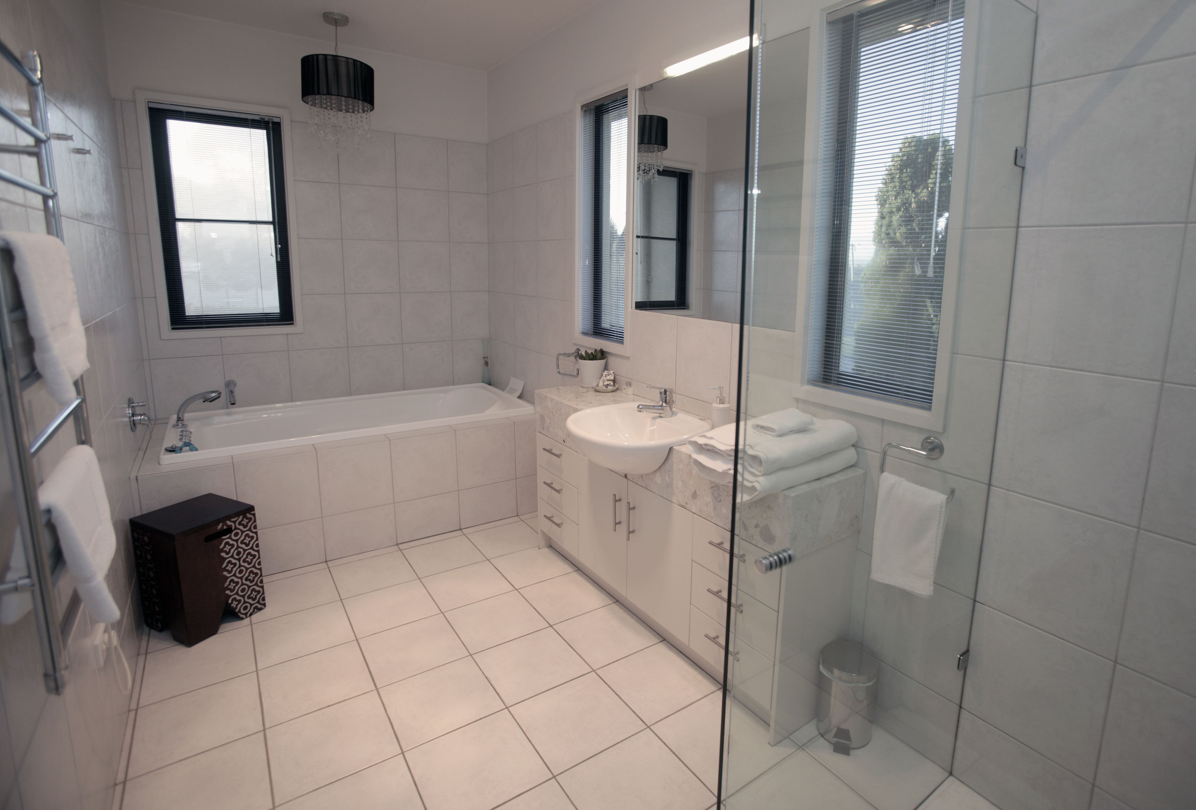 Un baño moderno con bañera, lavamanos y cabina de ducha de vidrio.