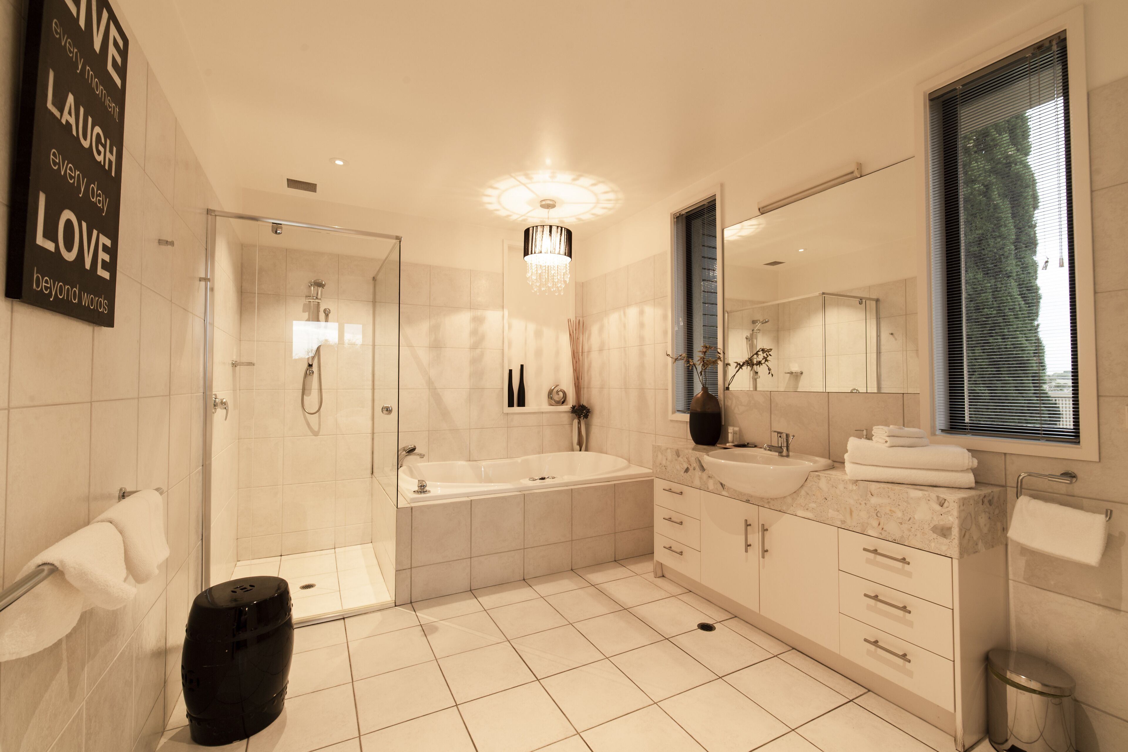 A modern bathroom with a large bathtub, a walk-in shower, and a vanity with a mirror.