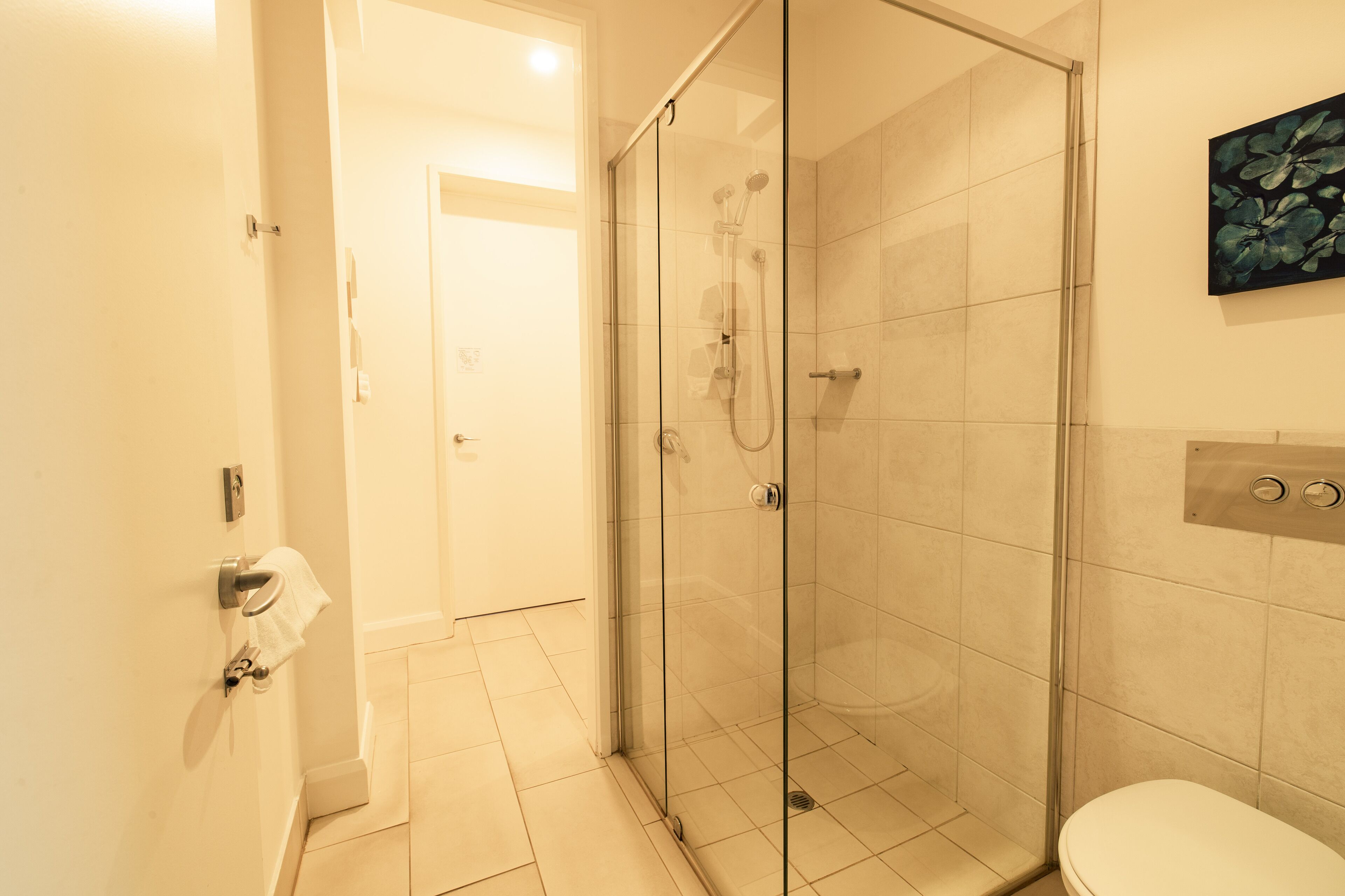 Un baño moderno con ducha de vidrio, inodoro y lavamanos.