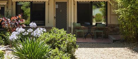 Une maison avec un patio, une petite table et des chaises.