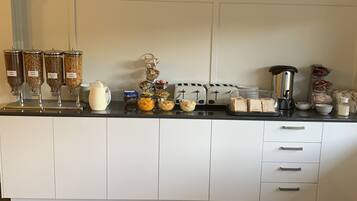 Un comptoir de cuisine équipé de distributeurs d’aliments, d’une machine à café et d’un grille-pain.