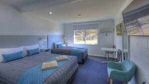 A hotel room with two beds, a desk, a chair, and a large window offering a view of the outdoors. - Glen Innes Motel (Glen Innes)